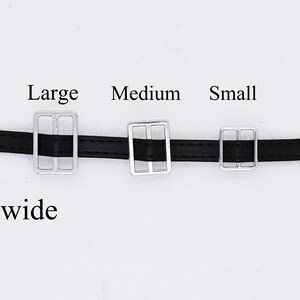 May include: Three silver belt buckles in different sizes, labeled "Large", "Medium", and "Small". The buckles are attached to a black leather belt that is 5mm wide.