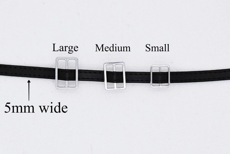 May include: Three silver belt buckles in different sizes, labeled "Large", "Medium", and "Small". The buckles are attached to a black leather belt that is 5mm wide.