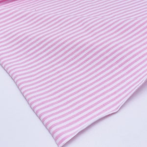 May include: Pink and white striped fabric with a soft, textured feel.