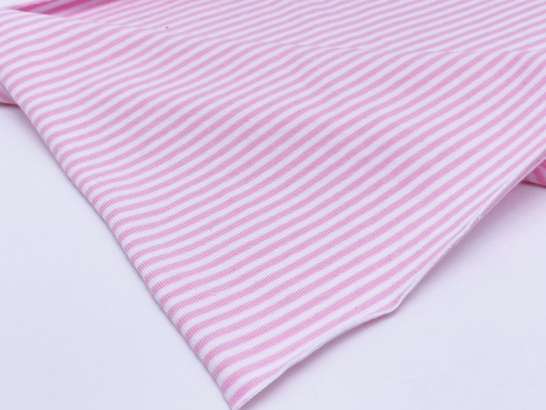 May include: Pink and white striped fabric with a soft, textured feel.