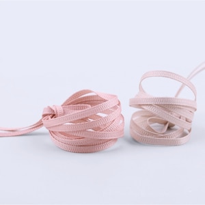 May include: Two spools of pink satin ribbon. The ribbon is thin and has a subtle ribbed texture.