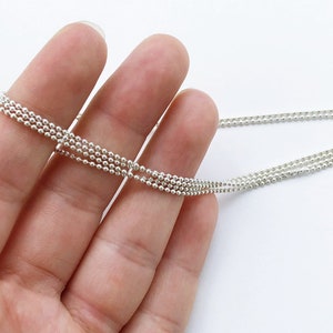 May include: A silver chain necklace with multiple strands of small, round beads.