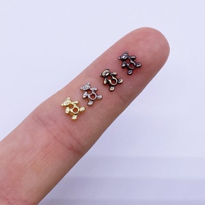 May include: Four tiny metal teddy bear charms in gold, silver, and bronze.