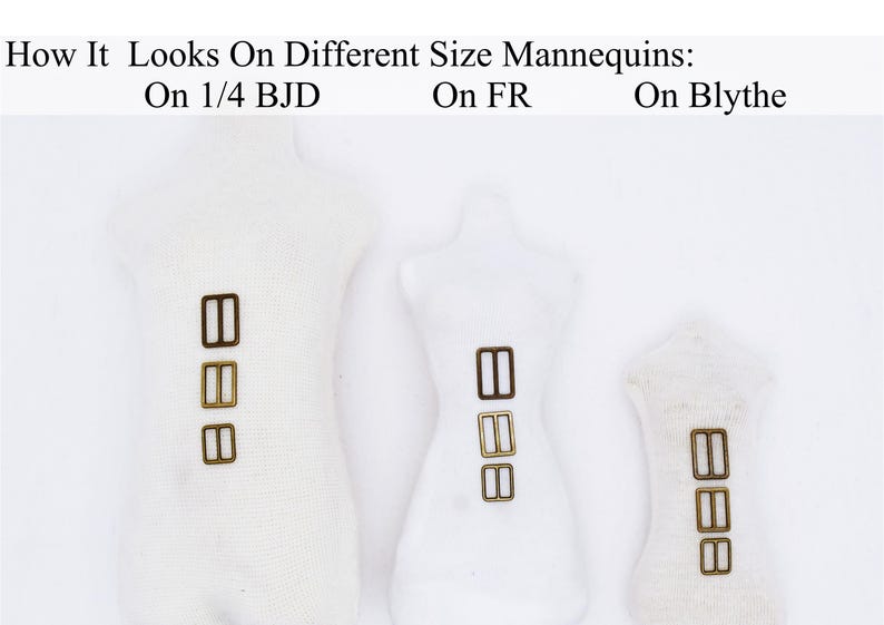 May include: Three white fabric mannequins of different sizes, each with three gold-colored metal slider buckles attached to the front. The mannequins are labeled "On 1/4 BJD", "On FR", and "On Blythe".