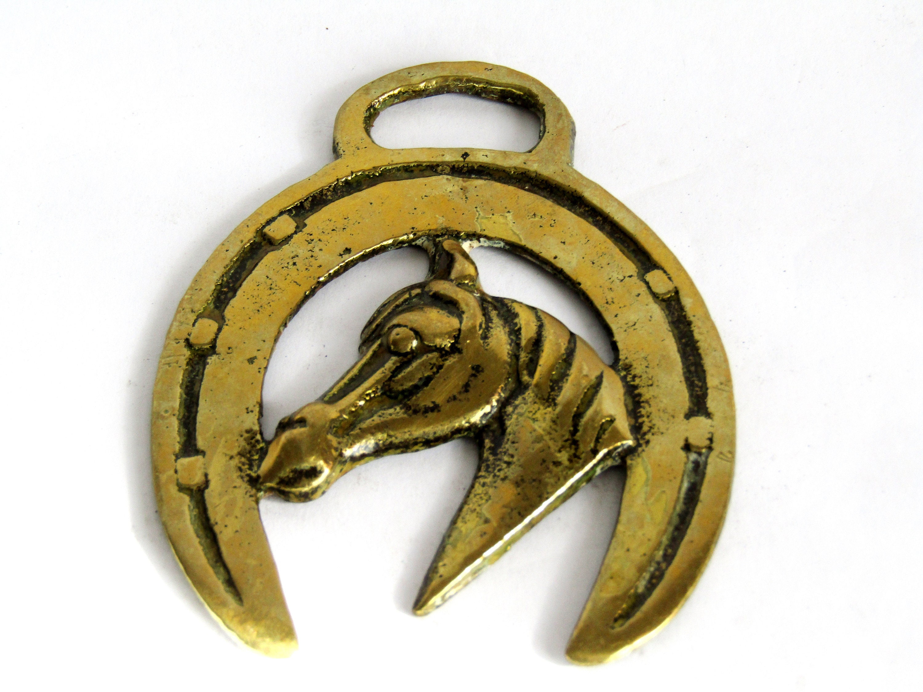 Vintage English Horsebrass featuring a horse's head inside a horseshoe