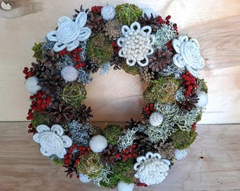 Corona navideña de musgo de lana: decoración artesanal de bayas y piñas con motivos del bosque.