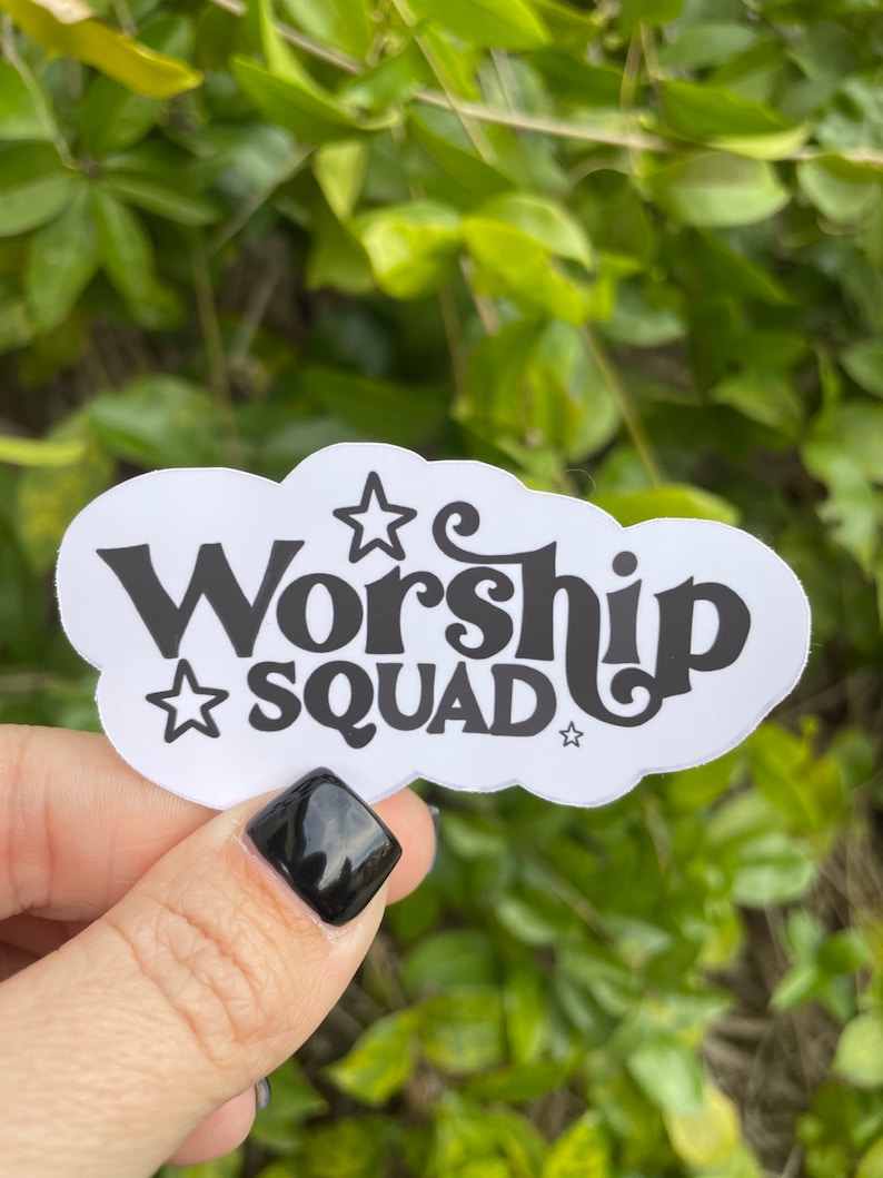 Puede incluir: Pegatina blanca con texto negro que dice "Worship Squad" con estrellas a cada lado del texto. La pegatina tiene forma de nube.