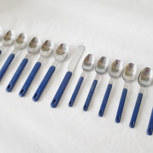 May include: A set of 12 silver spoons with blue handles. The spoons are arranged in a row on a white surface.