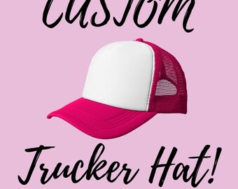 May include: A pink and white trucker hat with the text "CUSTOM" above and "Trucker Hat!" below. The hat has a white front panel, a pink brim, and a pink mesh back. The background is a light pink color.