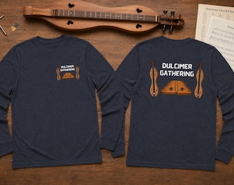 May include: A dark blue long-sleeve t-shirt featuring a graphic of two dulcimers and a hammered dulcimer with the text "DULCIMER GATHERING" printed on the front left chest and in a larger version on the back of the garment.