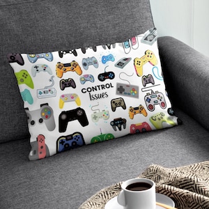 May include: White throw pillow with a colourful pattern of video game controllers. The text "CONTROL Issues" is printed in black on the pillow.