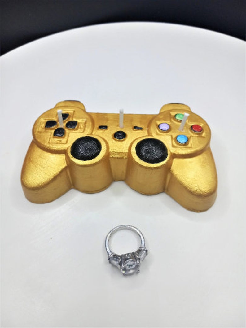 Gold game controller candle with colorful buttons on the right and black buttons.  Buttons are personalizable and can be black as well.