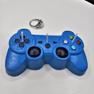 light blue game controller candle with bright colored buttons