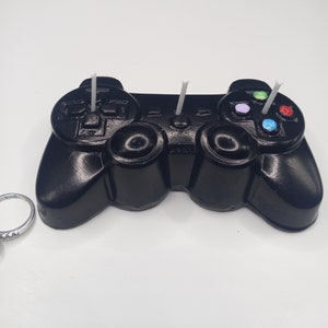 Black game controller candle with colored buttons