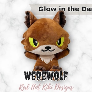 May include: A brown plush werewolf toy with green eyes and a white chest. The text "Glow in the Dark!" is above the toy, and the word "WEREWOLF" is below it. The text "Red Hot Kiki Designs" is also visible.