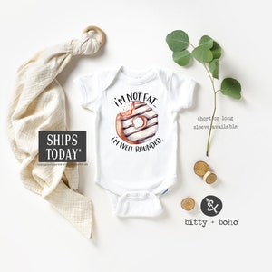 May include: White baby onesie with a donut graphic and the text "I'm not fat, I'm well rounded."