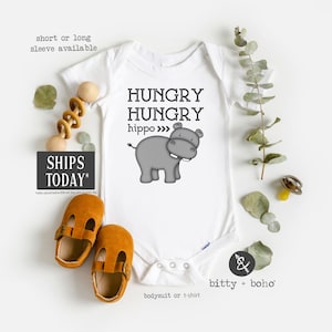 May include: White baby onesie with a gray hippopotamus illustration and the text "HUNGRY HUNGRY hippo >>>".