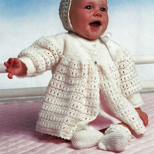 May include: A white crocheted baby outfit with a matching hat and booties. The outfit features a button closure and a delicate crocheted pattern.