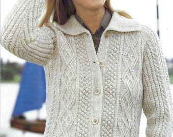 May include: A white knitted cardigan with a cable knit pattern and button closure. The cardigan has a collar and long sleeves.