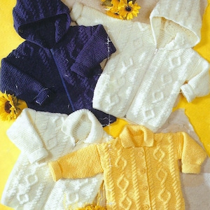 May include: Four knitted baby sweaters in different colors: blue, white, yellow, and cream. The sweaters have a cable knit pattern and are all hooded.