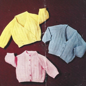 Puede incluir: Tres cárdigans de punto para bebé en diferentes colores: amarillo, azul y rosa. Cada cárdigan tiene un cierre de botón y una textura acanalada.