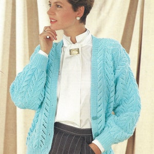 Puede incluir: Un cárdigan de punto azul claro con cierre de botones y un delicado patrón de encaje. El cárdigan tiene mangas largas y cuello en V.