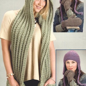 May include: A green hooded scarf with pockets, a purple knitted hat with earflaps, and brown knitted mittens.