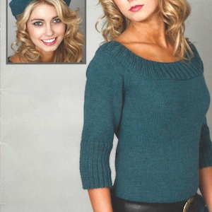 May include: A teal blue knitted sweater with a wide neckline and three-quarter sleeves. The sweater is worn with a black leather belt with a gold buckle.