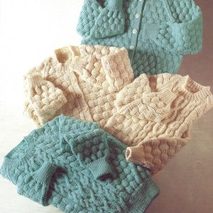 May include: Three knitted cardigans in different colours. One is a light green, one is a beige, and one is a darker green. All three cardigans have a textured pattern and button fastenings.