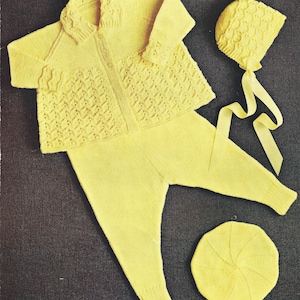 May include: A yellow knitted baby outfit with a matching hat and beret. The outfit includes a cardigan, trousers, and two hats.