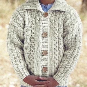 May include: A cream-colored knitted cardigan with a cable knit pattern and wooden buttons.