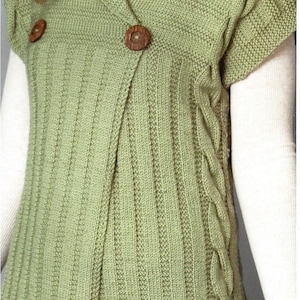 Puede incluir: Un chaleco de punto verde con cuello chal y cierre de botón. El chaleco tiene un detalle de punto trenzado en el lateral.