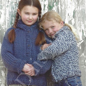 May include: Two young girls wearing blue knitted sweaters. The girl on the left is wearing a solid blue sweater with a button closure. The girl on the right is wearing a blue and white patterned sweater.