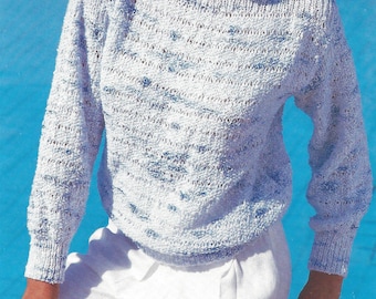 May include: A white and blue knit sweater with a loose fit and a boat neck. The sweater has a textured pattern and is made of a lightweight yarn.