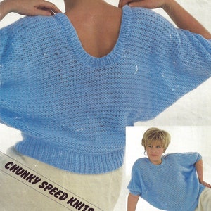 May include: A light blue knitted sweater with a wide neckline and short sleeves. The sweater is made with a chunky yarn and has a loose, relaxed fit. The sweater is shown on a model wearing a white skirt. The text "CHUNKY SPEED KNITS" is printed on the bottom of the image.