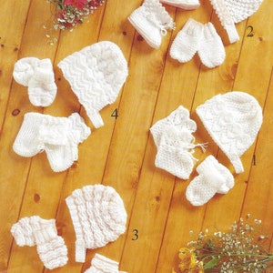 May include: Five sets of white crocheted baby hats, booties, and mittens. Each set is numbered 1 through 5.