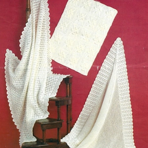 May include: Three white crocheted baby blankets, one draped over a wooden chair, one laid flat, and one folded in a triangle shape. All blankets are made with a delicate lace pattern.