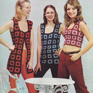 May include: Three women wearing crocheted vests. The vest on the left is long and red with black squares. The vest in the middle is blue with black squares. The vest on the right is pink with red squares. All three vests have a square pattern.