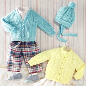 May include: Two knitted cardigans for babies, one in light blue and one in yellow, with button fastenings. Both cardigans feature a cable knit pattern. The blue cardigan is paired with plaid trousers and a matching blue knitted hat with a pom-pom.