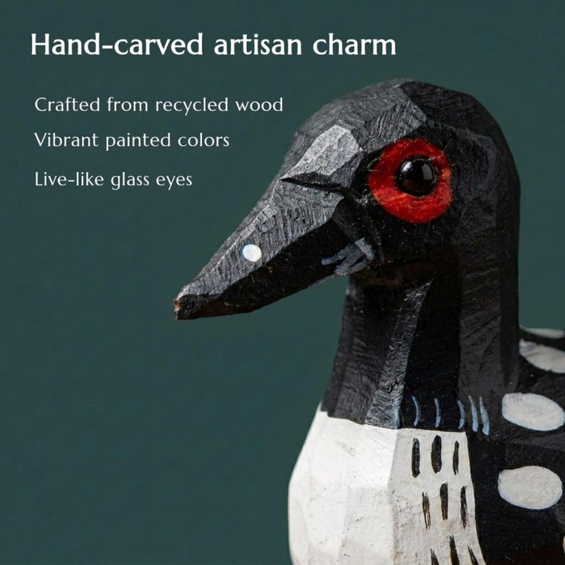 May include: A hand-carved wooden bird figurine featuring a black head and body with white spotted markings, a red patch around the dark glass eye, and a pointed beak. The text reads: Hand-carved artisan charm, Crafted from recycled wood, Vibrant painted colors, Live-like glass eyes.