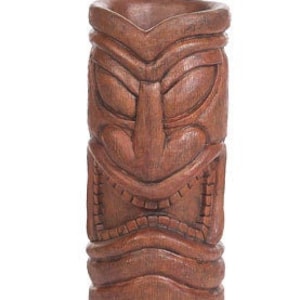 Puede incluir: Un mug tiki de madera marrón con una cara tallada y un diseño texturizado.