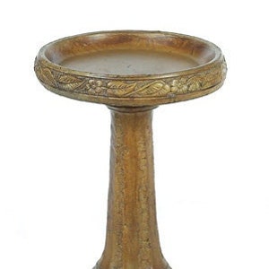 May include: A brown, decorative bird bath with a carved leaf design around the top rim. The bath has a round top and a tall, cylindrical base.