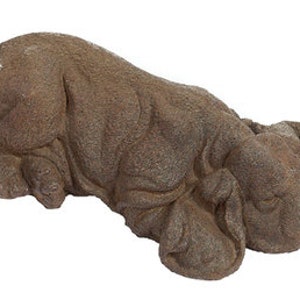 May include: A brown, sleeping, concrete sculpture of a dog. The dog is lying on its side with its head resting on its paws.