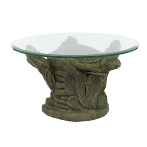 May include: A glass-top coffee table with a sculpted base featuring a turtle design. The base is made of a brown, textured material and has a leafy design.