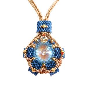 Puede incluir: Un collar de cuentas azul y dorado con un colgante que presenta un cristal grande y una cuenta cuadrada más pequeña. El colgante está hecho con una variedad de cuentas, incluyendo cuentas de semillas, cuentas de bugle y un cristal grande. El collar se llama "Dakota beading pattern by bizSuterie".