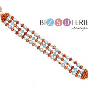 Op de afbeelding: Een meerrijige armband met koperkleurige rechthoekige kralen en lichtblauwe glazen kralen. De armband heeft een zilveren sluiting.