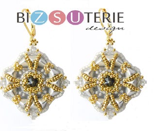May include: A pair of gold and silver beaded earrings with a square shape and a crystal in the center. The earrings are hanging from gold hooks.