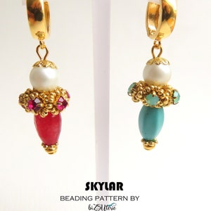 May include: A pair of gold hoop earrings with a dangling charm. Each charm features a white pearl, a cluster of gold beads, and a teardrop-shaped stone. One stone is red and the other is turquoise.