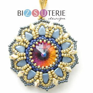 Può includere: Un ciondolo di perline con un grande cristallo iridescente al centro. Il ciondolo è circondato da perline dorate, blu e bianche. Il ciondolo è etichettato "Bizuterie design".