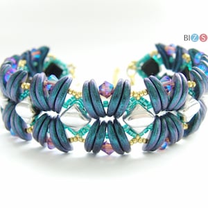 May include: A teal, purple, and silver beaded bracelet with a geometric design. The bracelet is made with small, round beads and has a clasp closure.